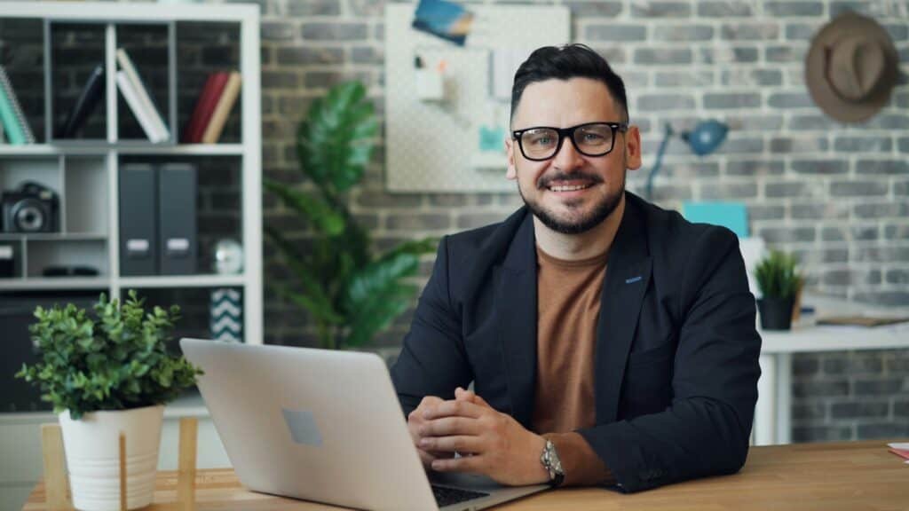 Man seated at a desk with a laptop