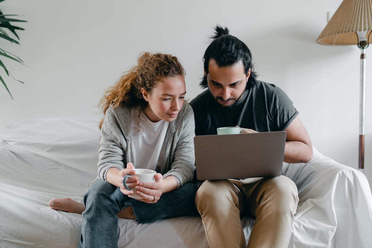 Young couple using laptop computer to get emergency cash