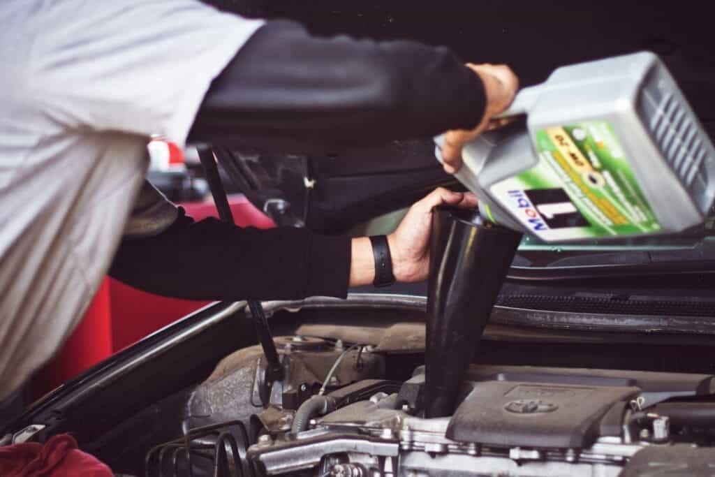 Man refilling car engine motor oil