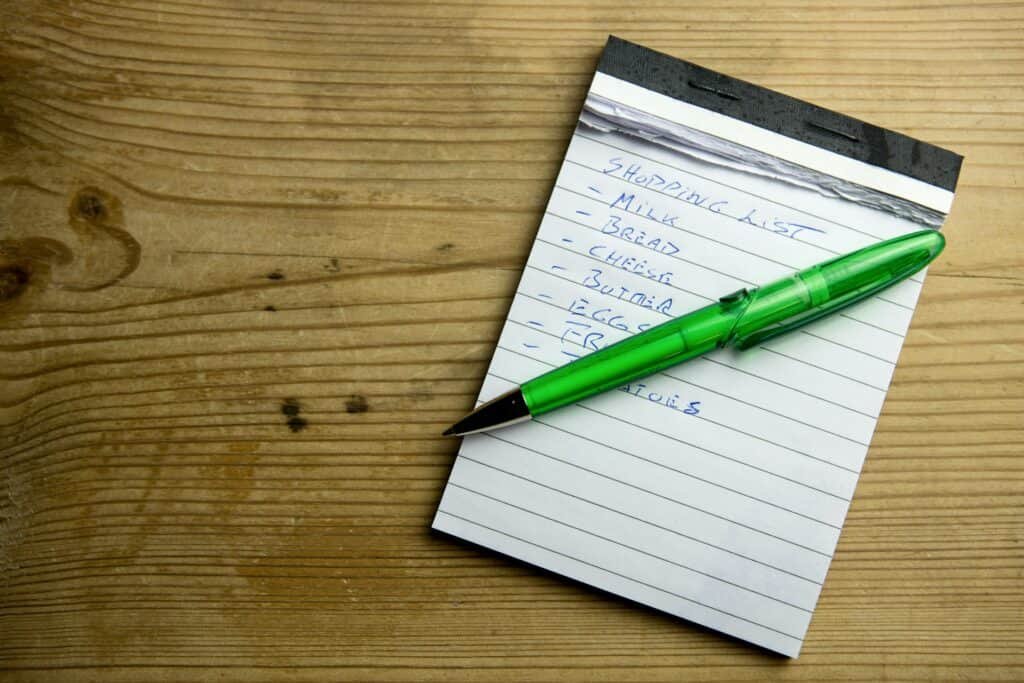 Shopping list on a writing pad and a pen