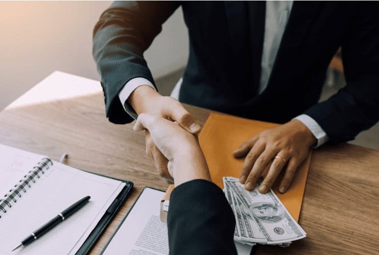 People shaking hands after a money transaction