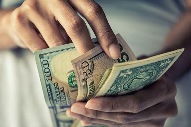 A person counting money before giving an emergency loan