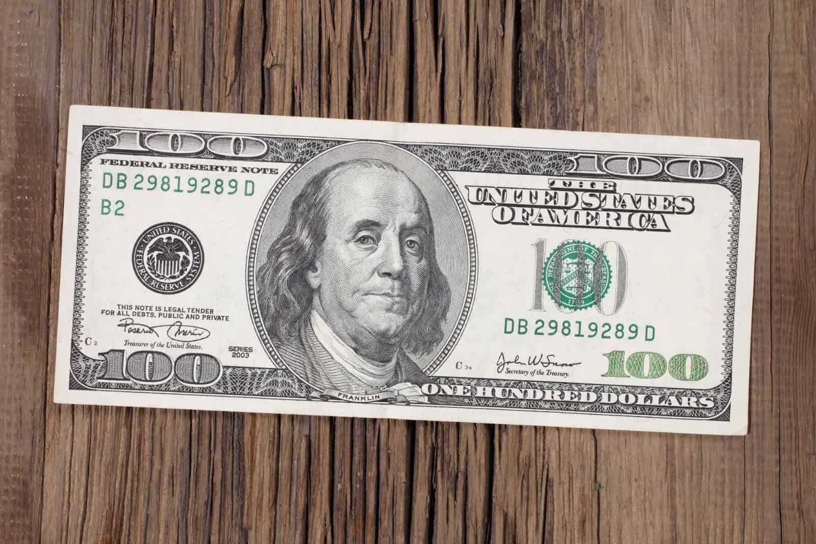 $100 bill on a wooden table