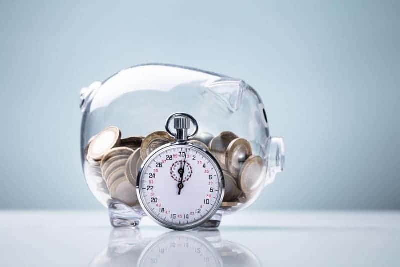 A see-through piggy bank with a stopwatch next to it