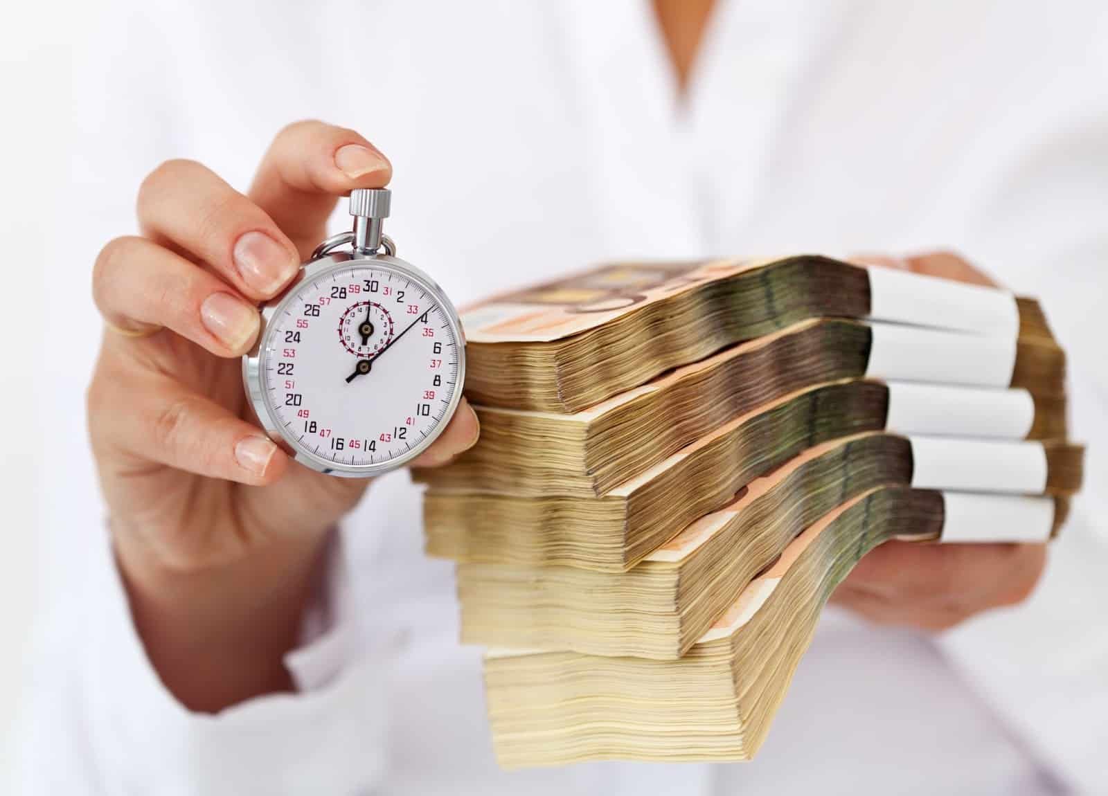 Person holding out a stopwatch and bundles of cash