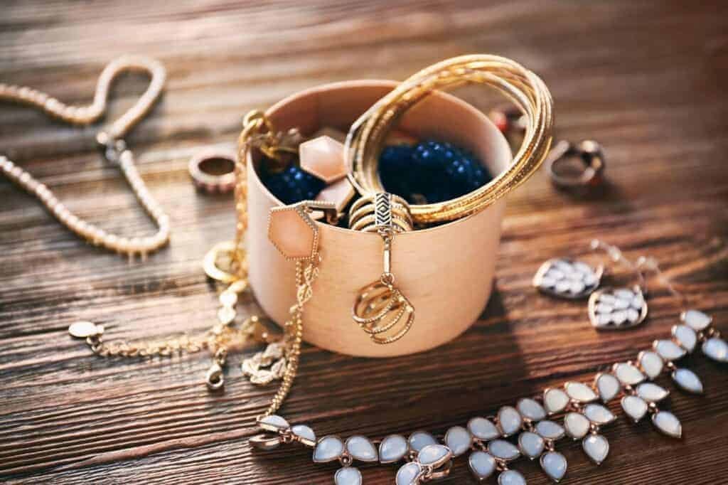 Jewelry and an open jewelry box on wooden table