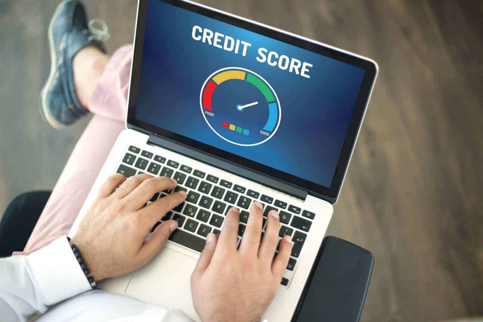 Man seated with his laptop looking at a credit score