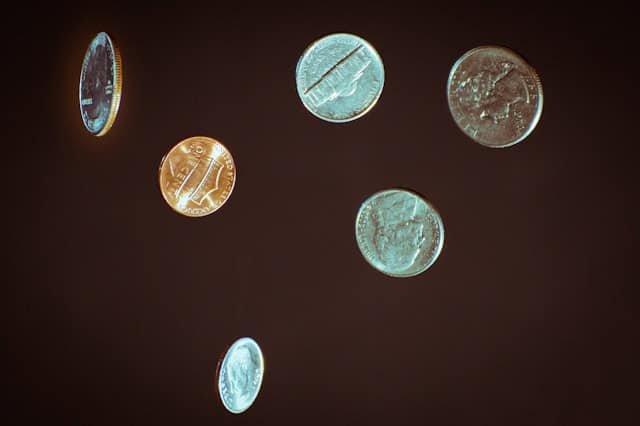 Falling US coins symbolizing growing interest rates and fees