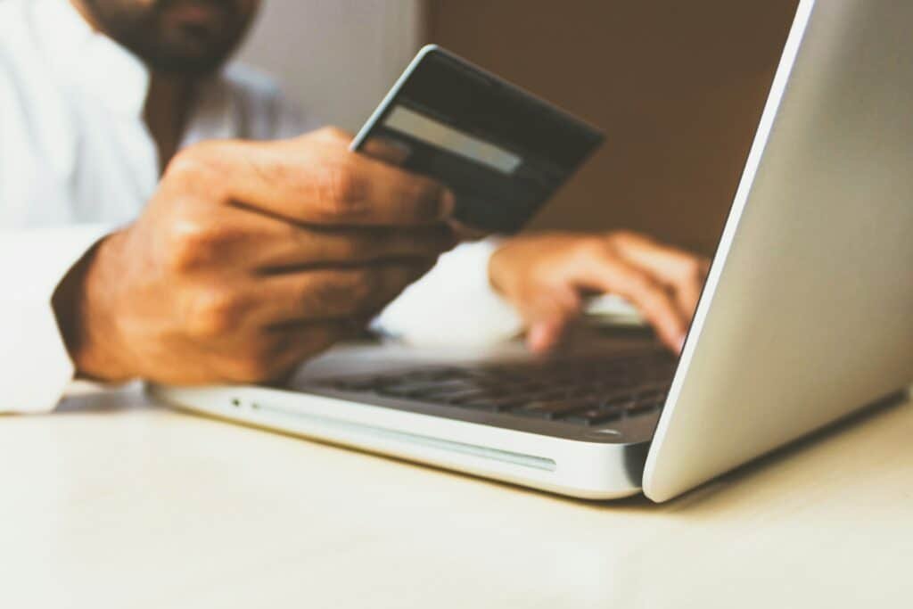 Man using his laptop holding a credit card